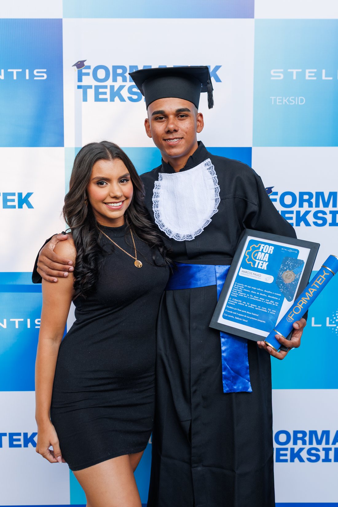 Formando ao lado da família no painel da formatura